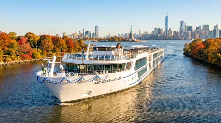 Le navire de croisière American Ranger naviguant sur l'Hudson avec la Statue de la Liberté et New York en arrière-plan.