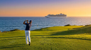 Un golfeur effectue un swing sur un terrain côtier au coucher du soleil avec un navire de croisière en arrière-plan.